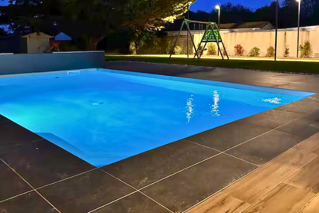 Piscine extérieure de nuit avec éclairage
